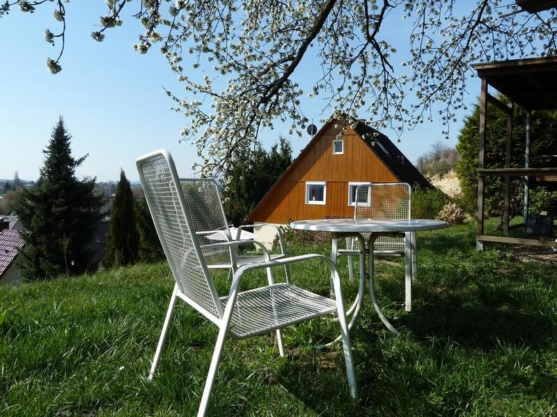 Haus mit Garten und Sitzgruppe unter einem blühenden Baum